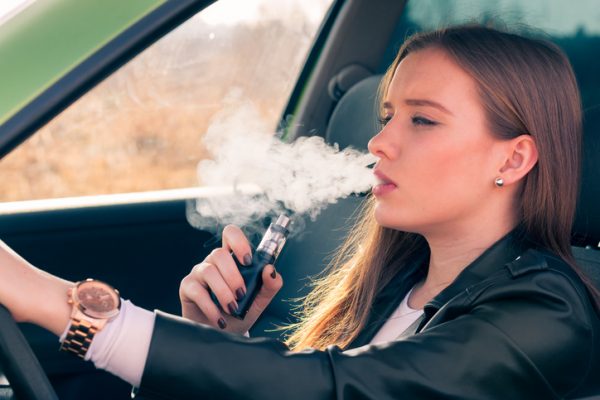 Woman Vaping behind the wheel